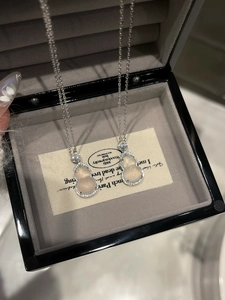 Detail of silver stainless steel gourd pendant necklace with white jade and zircon in a box