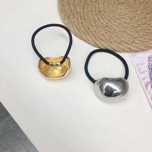 Detail of high-elasticity hair ties with polished gold and silver bean charms in 2-piece set
