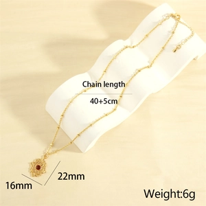 Detail of red gemstone pendant with hollow pattern frame on 18K gold plated necklace