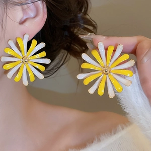 Primo piano di un orecchino a margherita giallo e bianco indossato da una modella