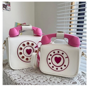 Close-up of two creative white and pink telephone shaped PU leather crossbody bags