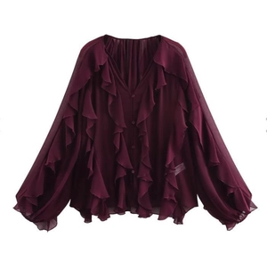 Detail of layered ruffles on dark purple chiffon blouse with buttons and long sleeves