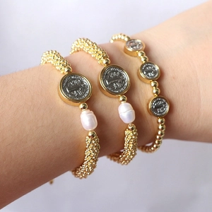Detailed close-up of a vintage three-piece bracelet set with gold beads and pearl