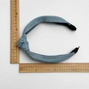 Vue détaillée du bandeau en denim bleu avec nœud et embouts en tissu noir antidérapant