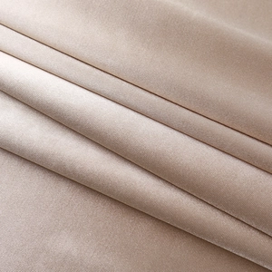 Gros plan sur le tissu en satin champagne avec un drapé élégant et une texture soyeuse