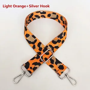 Detail view of light orange leopard print nylon bag strap with silver metal hooks