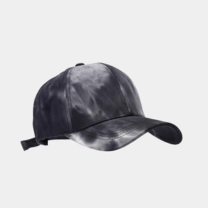 Détail d'une casquette tie-dye avec motifs noir et blanc et sangle de réglage à l'arrière