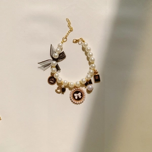 Elegant pearl pet collar with gold crown charms and black ribbon for cats and dogs