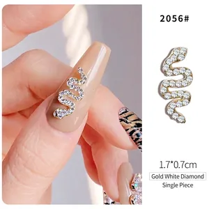 Macro detail of a 1.7x0.7cm gold snake nail art charm with sparkling white rhinestones