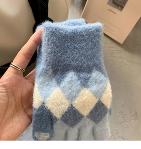 Close-up of knit glove featuring classic blue Argyle diamond pattern and ribbed cuff