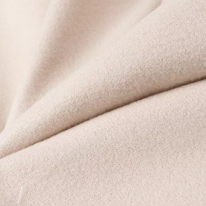 Macro shot of high-density oatmeal wool fabric showing soft texture and premium weave detail