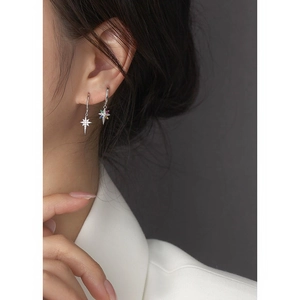 Macro detail of asymmetric star-shaped s925 silver earrings with colorful rhinestones