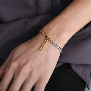 Close-up of dual-tone gold and silver Cuban link bracelet on model's wrist