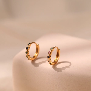 Close-up of 18K gold plated huggie earrings featuring multi-colored zircon stones