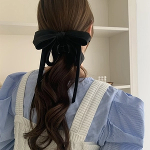 Elegant black fabric bow hair claw clip for women shown on low ponytail hairstyle