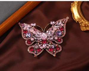 Detailed view of vintage crystal butterfly brooch with pink and red rhinestones