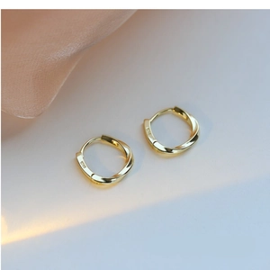 Detail of S925 sterling silver stamp on minimalist gold-plated twist hoop earrings