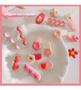 Detail of pink Y2K style resin heart and floral hair clips for girls on a white ceramic plate