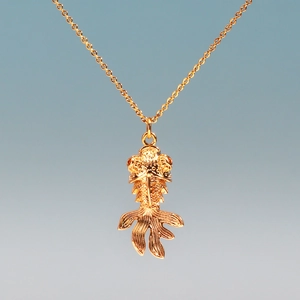 Macro view of a gold-plated koi fish pendant necklace with intricate texture and fine chain