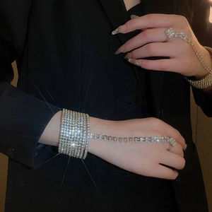 Macro detail of elegant silver hand chain with layered rhinestones on a black background