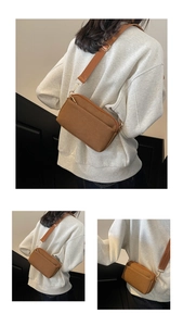 Detail of brown canvas crossbody bag with adjustable strap and golden hardware on model