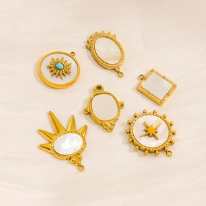 Six gold-plated DIY pendants with mother of pearl shell insets on white satin fabric