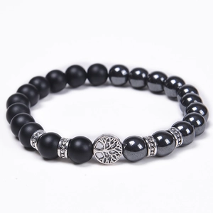Detail of beaded bracelet with matte black beads and silver tree of life charm