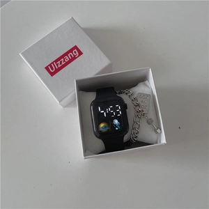 Close-up of LED sport watch and engraved metal bracelet set in a white gift box