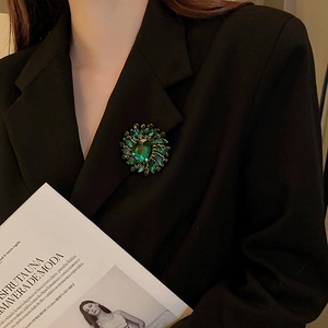 Vintage emerald green sunflower brooch with crystals on a black blazer lapel
