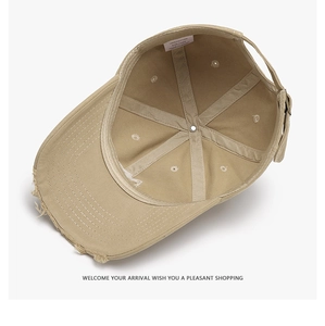 Detail of adjustable metal buckle and interior cotton seams on distressed khaki cap