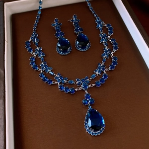 Détail d'une parure de bijoux avec collier et boucles d'oreilles zircon bleu goutte