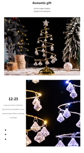 Macro shot of gold spiral Christmas tree lamp with crystal pendants and warm LED lights