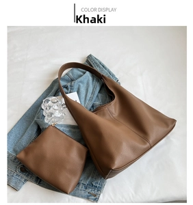 Detail of khaki pebbled leather tote set with matching pouch on white fabric background