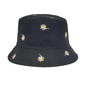Close-up of high-quality white daisy embroidery and cotton texture on a black bucket hat