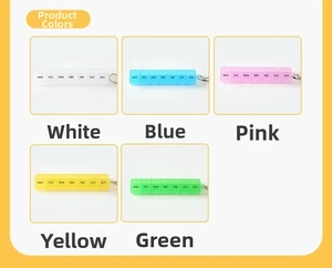 Detail of 7-day mini pill organizers in five colors with keychain and English weekday labels