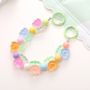 Close-up of acrylic candy-colored tulip beads with mint green plastic rings for DIY charms