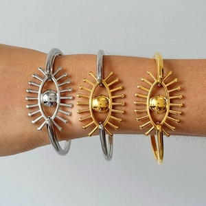 Vue détaillée de trois bracelets Evil Eye en finitions or et argent sur le poignet