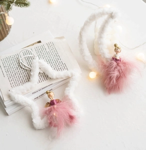Detail of two moon ballet girl ornaments with pink feathers and plush white moons