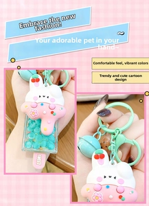 Detailed view of pink rabbit cream ice cream keychain with mint green bell and blue beads