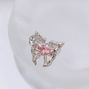 Macro shot of liquid metal silver butterfly ring with an oval pink zircon gemstone