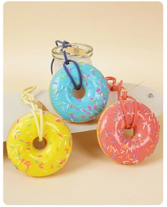 Dettaglio di tre ciondoli a ciambella in PU colorati con zuccherini e etichette