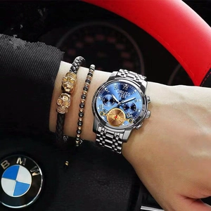 Close-up of business quartz watch with blue dial and steel strap worn with bracelets