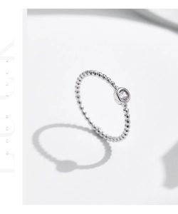 Dettaglio anello in argento S925 con fascia a pallini e diamante rotondo incastonato