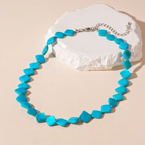 Dettaglio ravvicinato della collana con perle quadrate turchesi su roccia con chiusura