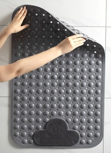 Detail showing non-slip suction cups and drainage holes on grey bathroom mat