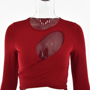 Detail eines roten Langarm-Crop-Tops mit asymmetrischem Ausschnitt und Wickeldesign