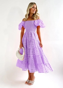 Detail of purple off-shoulder dress featuring plaid texture and tiered cake skirt layers