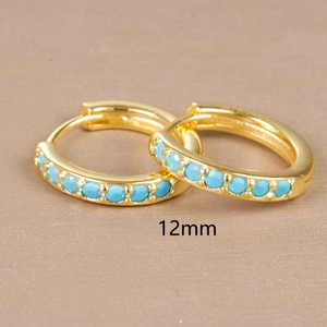 Macro detail of 12mm golden hoop earrings with turquoise beads on tan background