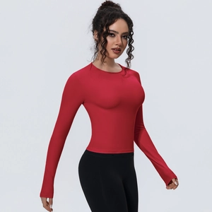 Vue latérale du haut de yoga rouge à manches longues et du legging de sport noir ajusté