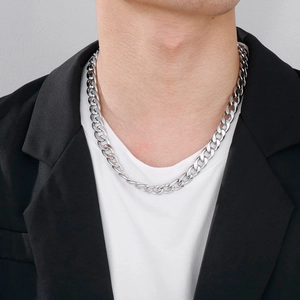 Close-up of polished silver stainless steel Cuban link chain necklace on a male model